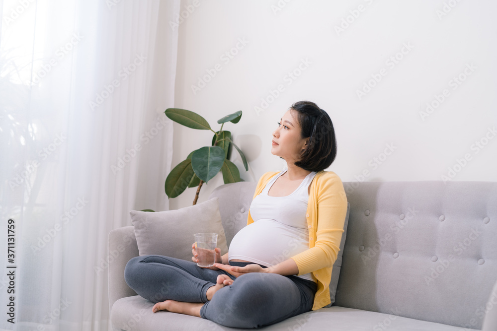 Vitamins for pregnant Expectant woman holding bunch of pills and glass of water