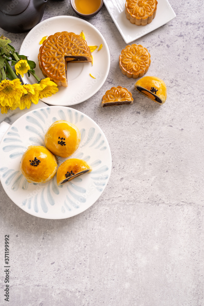 Tasty baked egg yolk pastry moon cake for Mid-Autumn Festival on bright cement table background. Chi