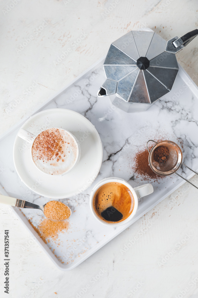 Tray with cups of hot coffee on white background