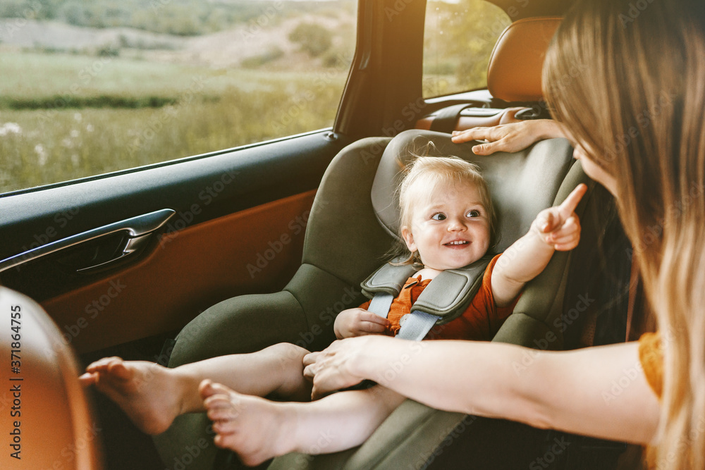 车里的孩子婴儿坐在安全座椅上母亲系好安全带家庭生活方式与ki一起旅行度假