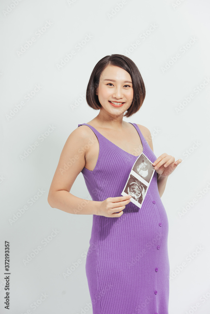 一位快乐的孕妇展示了她的超声波照片。母性的概念