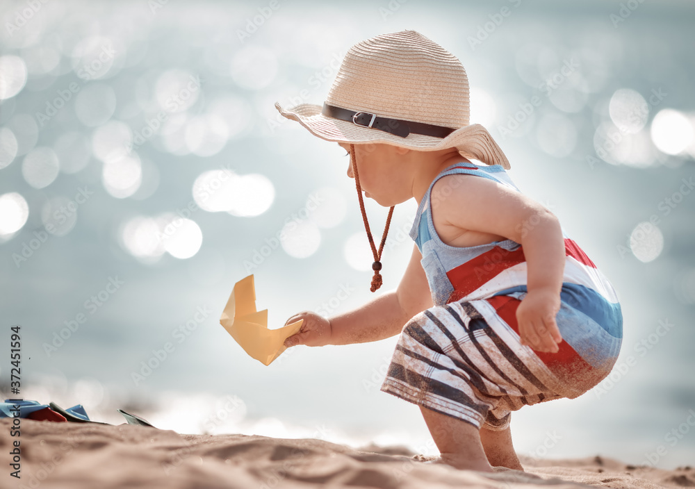 戴草帽在海滩玩耍的小男孩