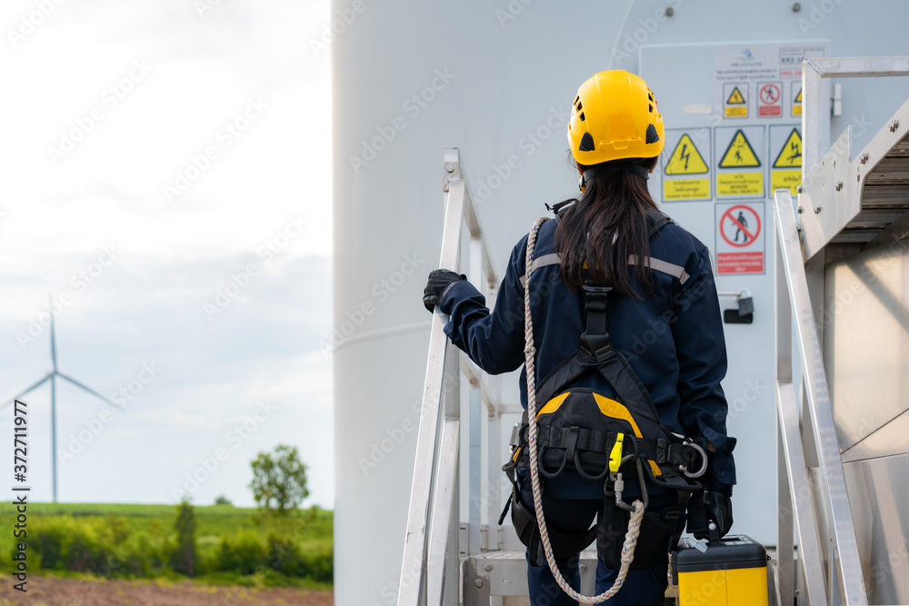 亚洲女性检查工程师，为风电场中的安全风力涡轮机进行准备和进度检查