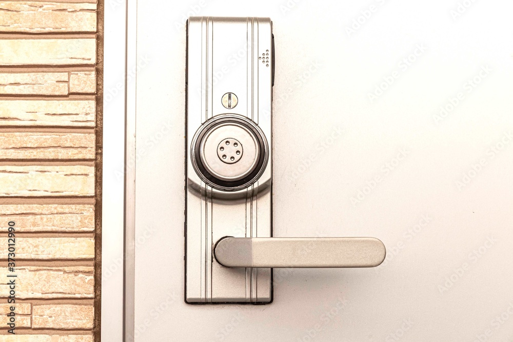 金属门上带安全系统锁的现代门把手