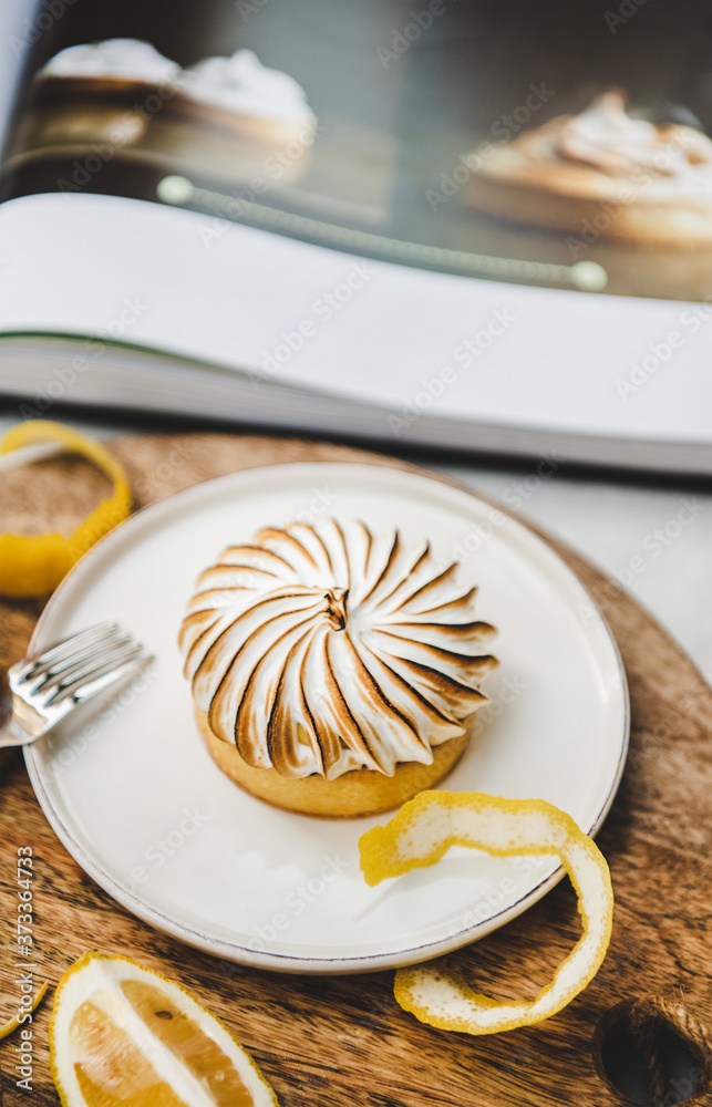 咖啡馆白色大理石桌子上的柠檬挞配梅伦格甜甜点，特写，选择性