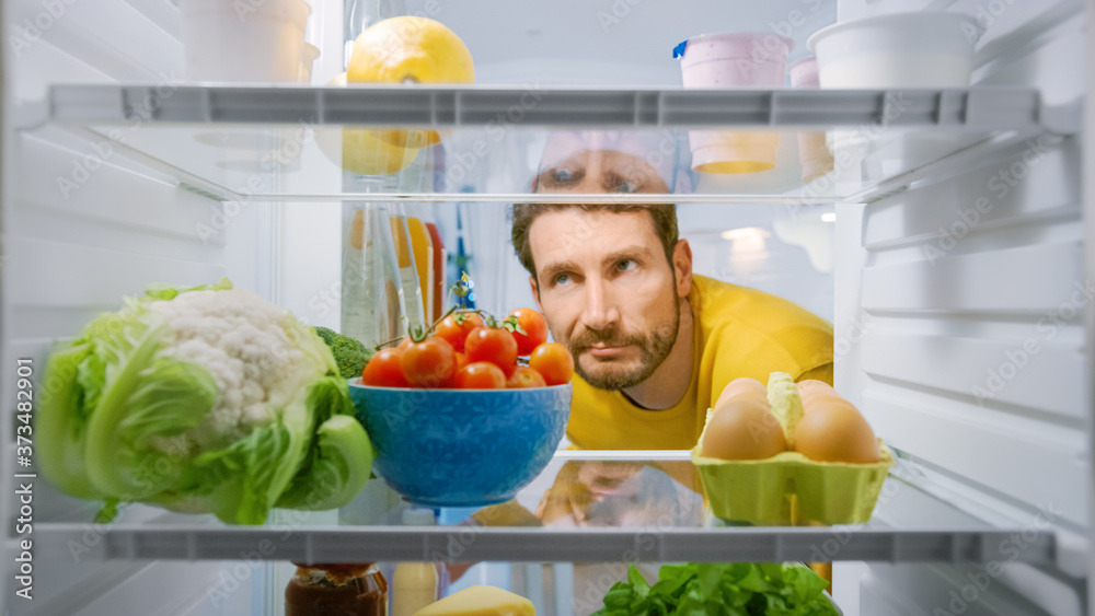 Inside Kitchen Fridge: Young Disappointed Man Looks inside the Fridge. Man Found Nothing for His Sna