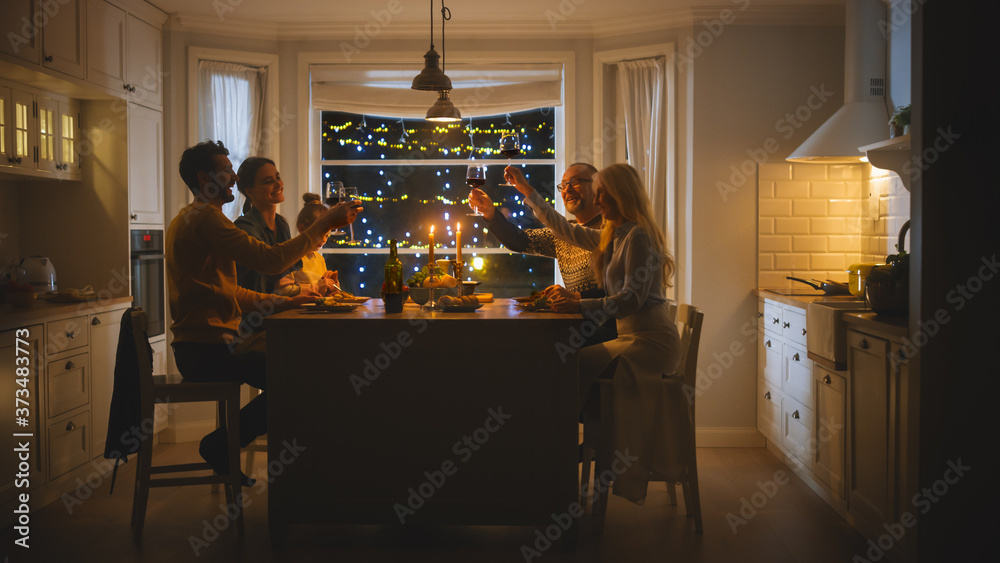 快乐的一家人一起庆祝，坐在桌子旁吃美味的晚餐。小孩子，