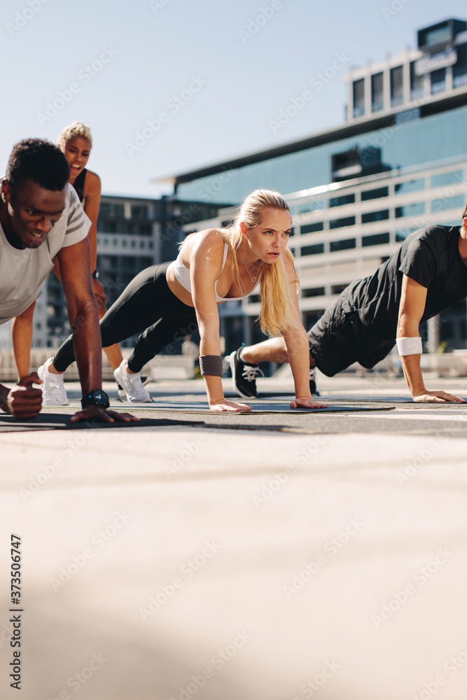Healthy people doing core workout outdoors