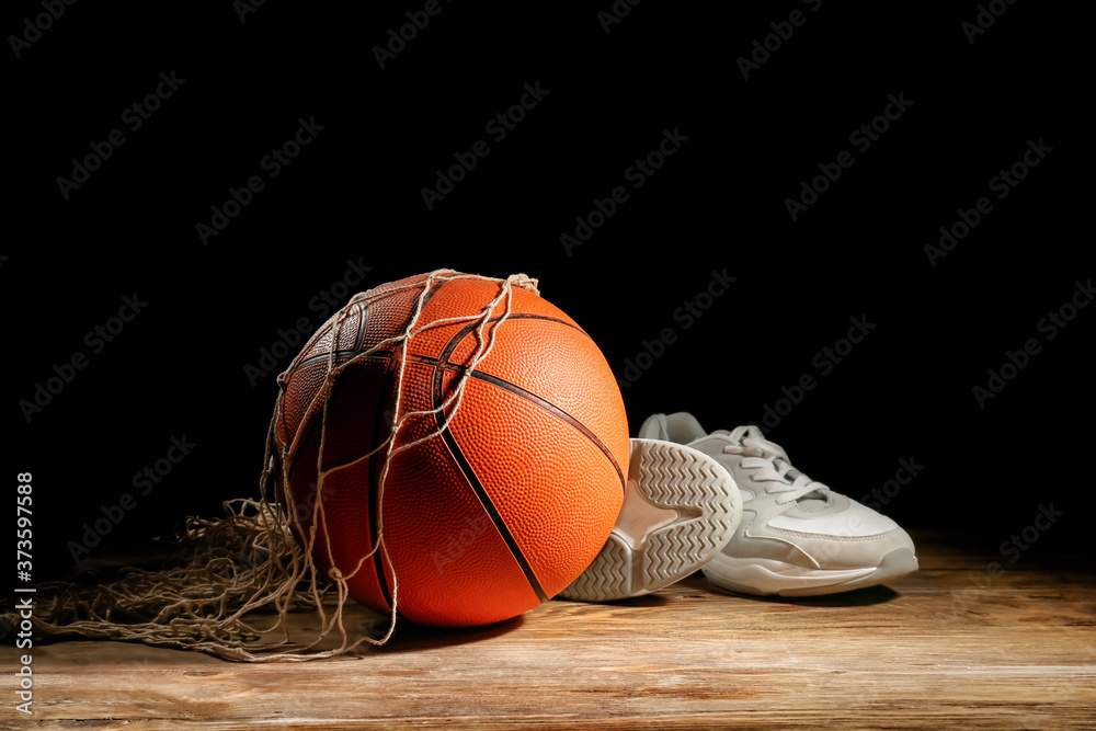 打篮球的球和桌子上深色背景的鞋子