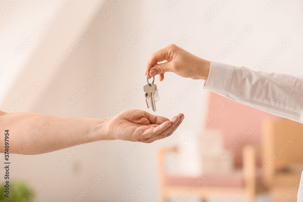 房地产经纪人将房子钥匙交给室内新主人