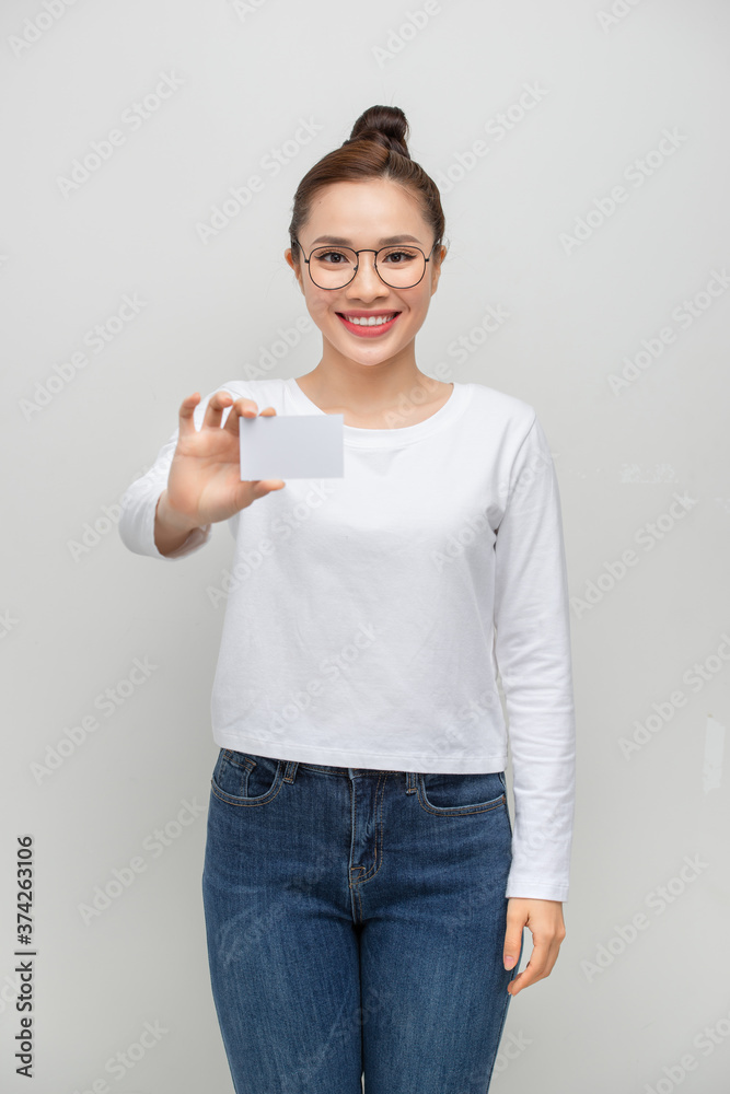 年轻的亚洲女性指着一张白底空白卡片