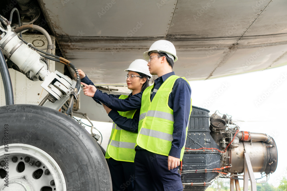 Asian man and woman engineer maintenance airplane team repairs, fixes, modernization and renovation 