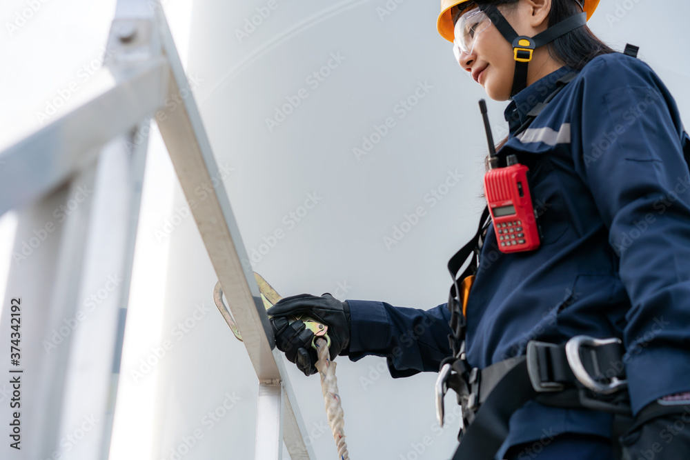 亚洲女检验工程师佩戴安全带和安全线工作准备和进展