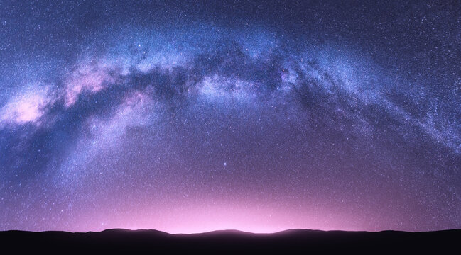 银河拱门。明亮的拱形银河，紫色的天空中有星星，粉红色的奇妙夜景