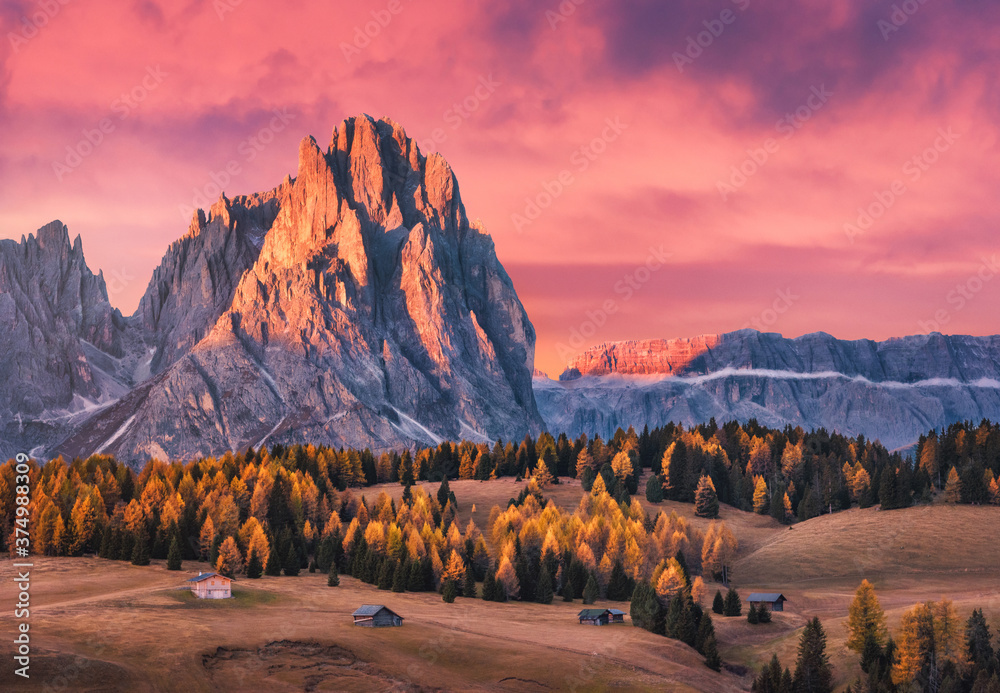 美丽的山脉，日落时有明亮的山峰和红色的天空。秋天的风景带着小木头hou