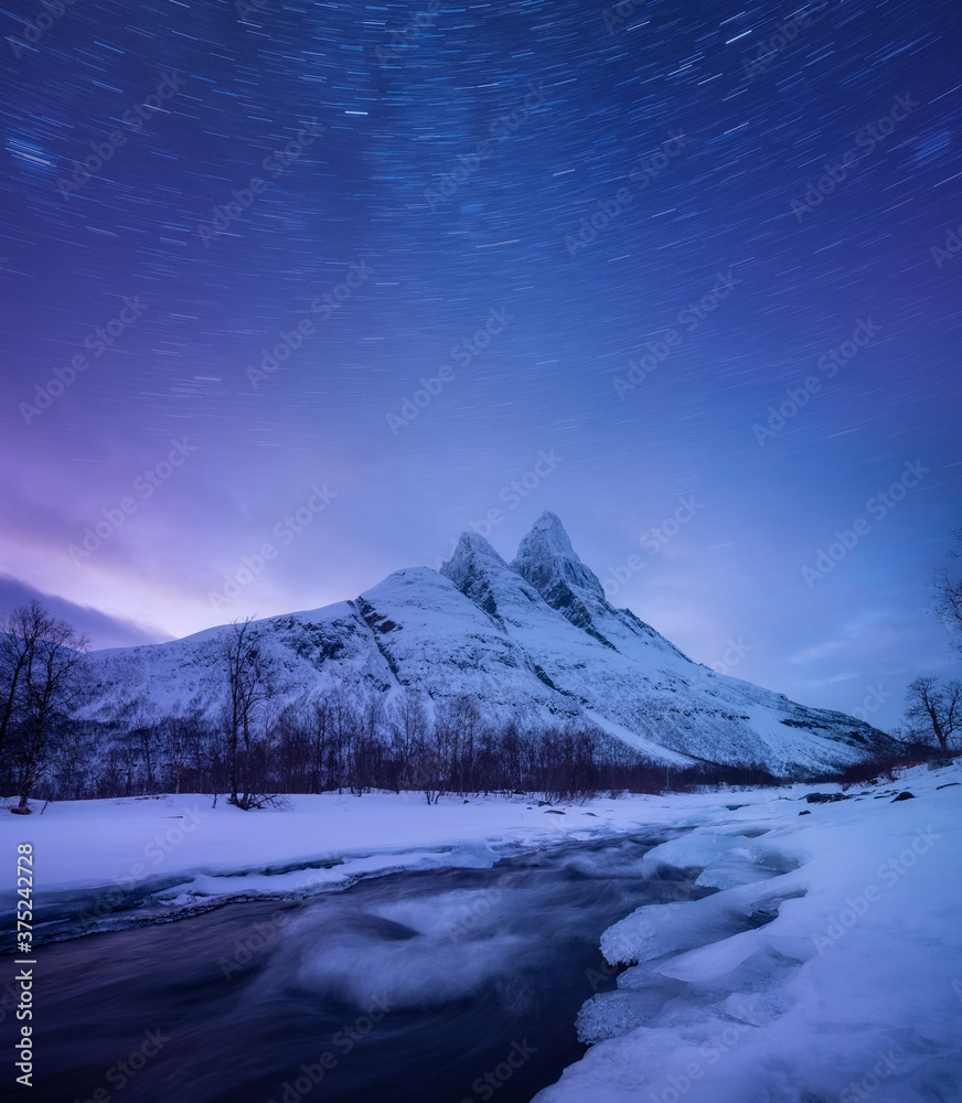 挪威森贾岛的山脉和星空。夜晚天空的冬季景观。河流和莫