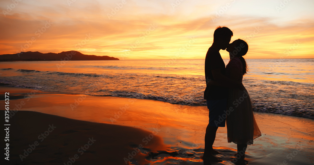 情侣站在日落海滩上