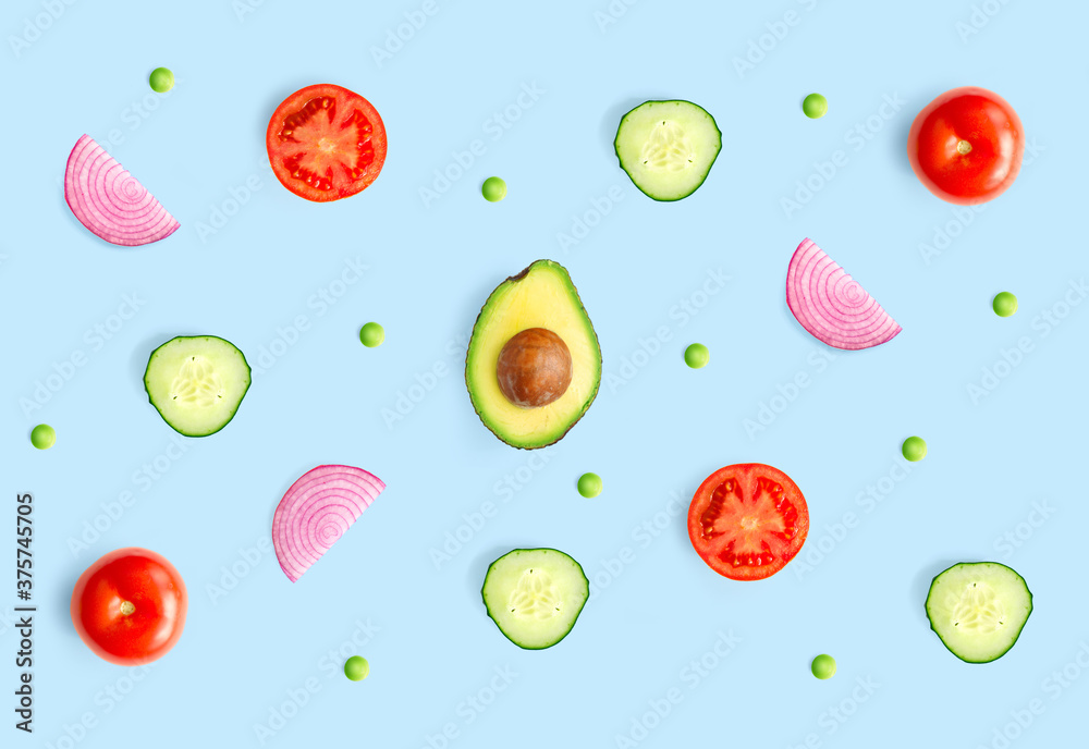 Creative layout made of green peas, avocado, tomato, onion and cucumber on the white background.. Fl