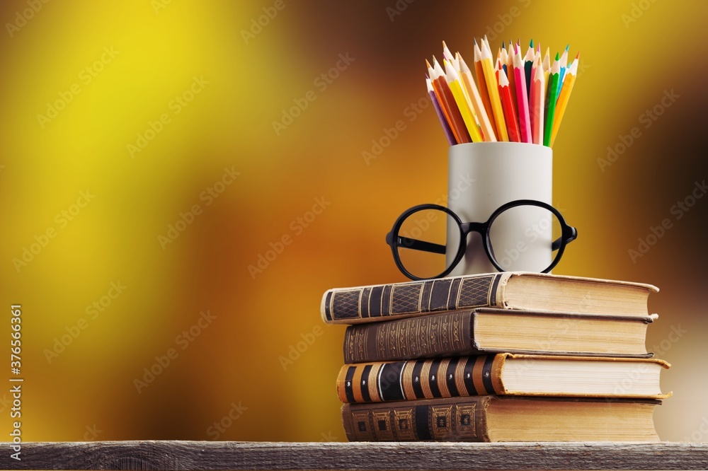 一堆旧书、眼镜和铅笔，教育和学习