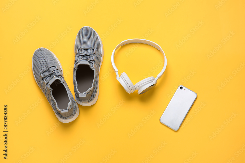 彩色背景运动鞋、手机和耳机