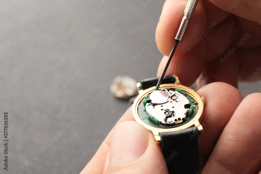钟表匠在餐桌上修理坏手表，特写镜头