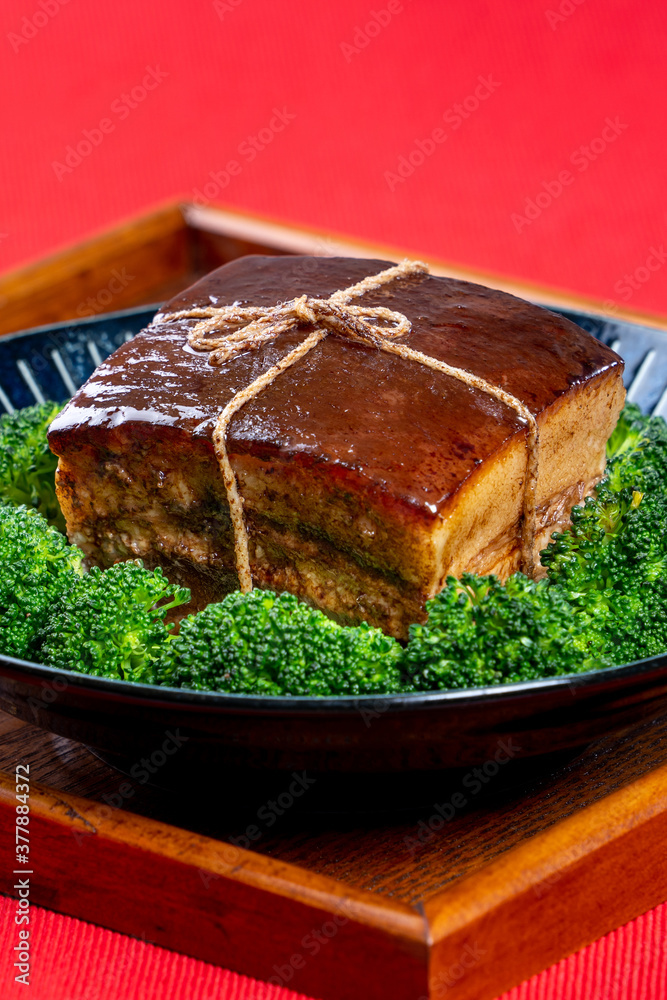 东坡肉（东坡肉）配绿色西兰花蔬菜，放在一个漂亮的蓝色盘子里，传统
