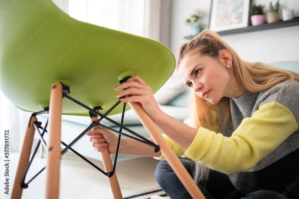 专注女性在家用螺丝刀修理椅子DIY概念