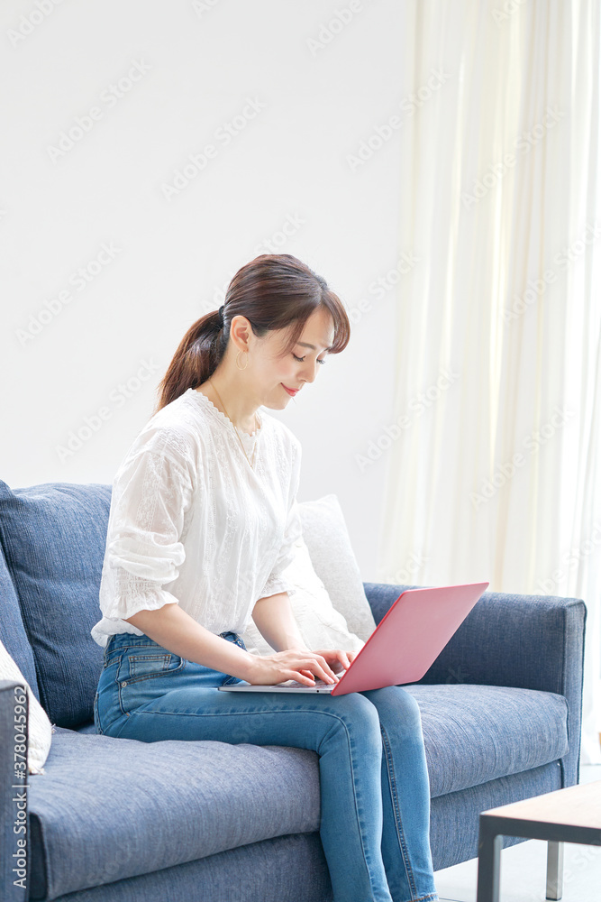 ソファーでパソコンを使う女性