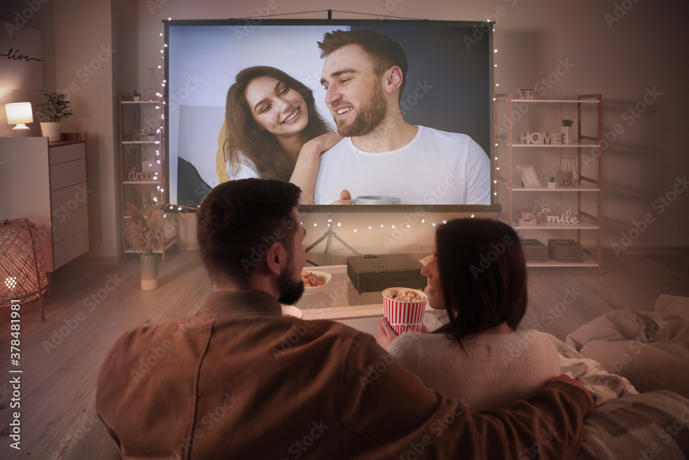 Young couple watching movie at home