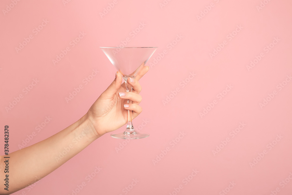 Hand with empty glass on color background