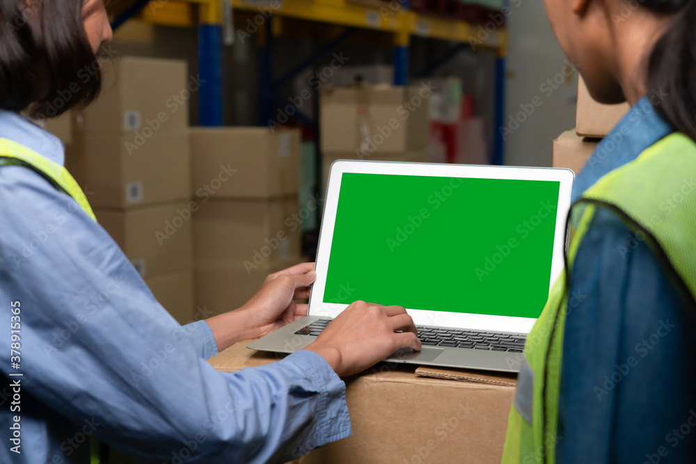 Computer with green screen display in warehouse storage room . Delivery and transportation software 