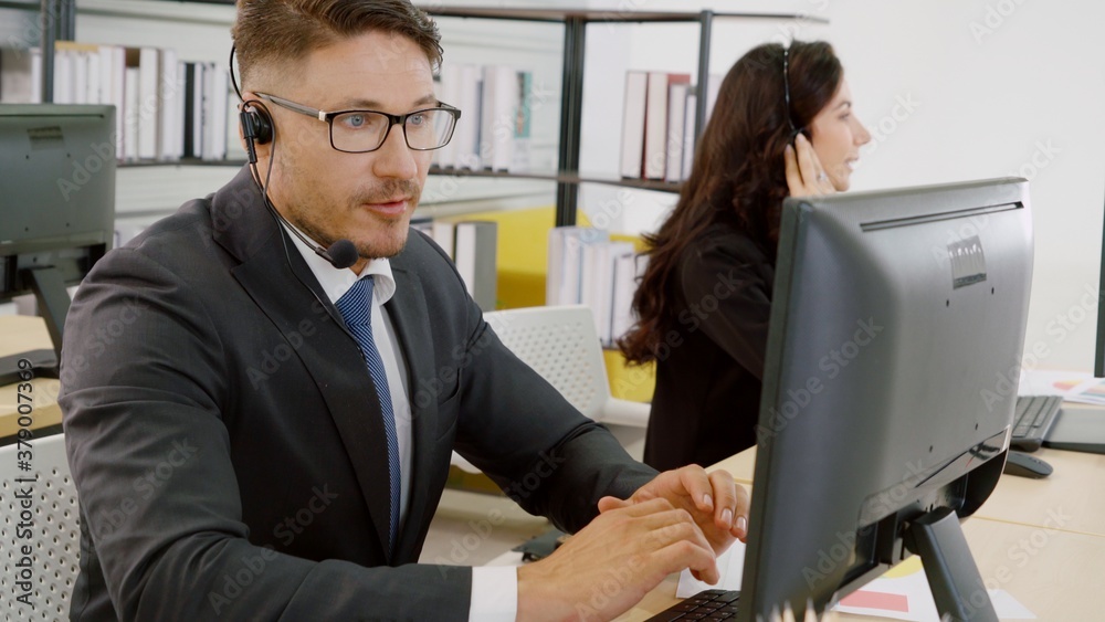 Business people wearing headset working in office to support remote customer or colleague. Call cent