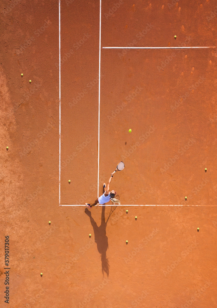 健康生活。一个年轻女孩在球场上打网球。从空中俯瞰网球场