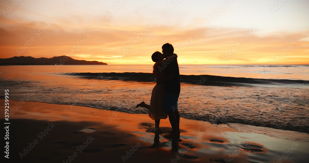 couple walk on sunset beach