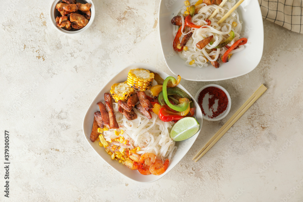 Bowls with tasty rice noodles on table