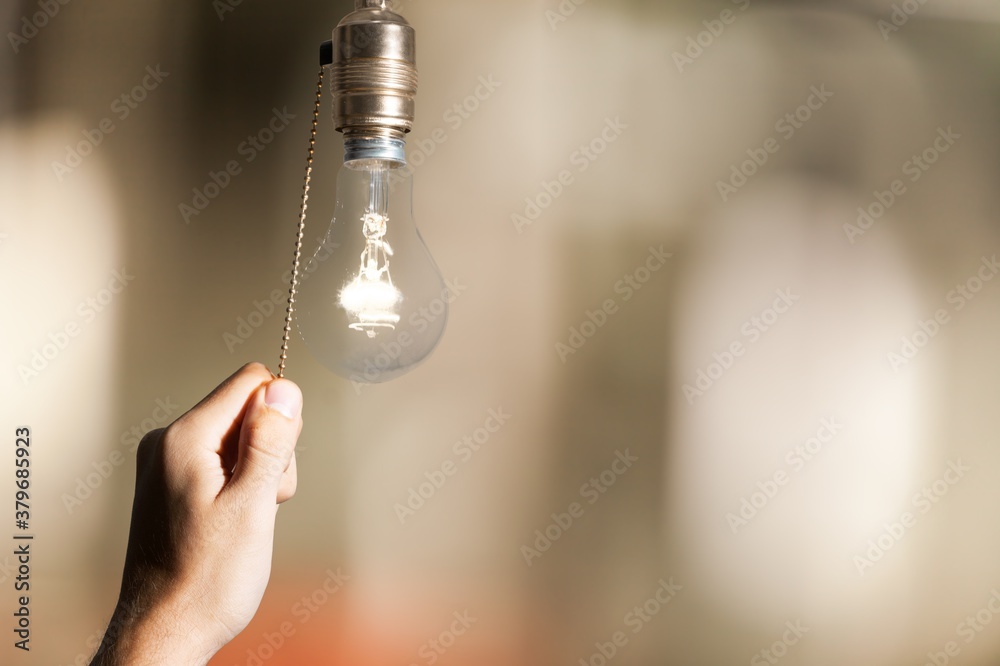 Hand turning off the bulb lamp.Turning off the light.