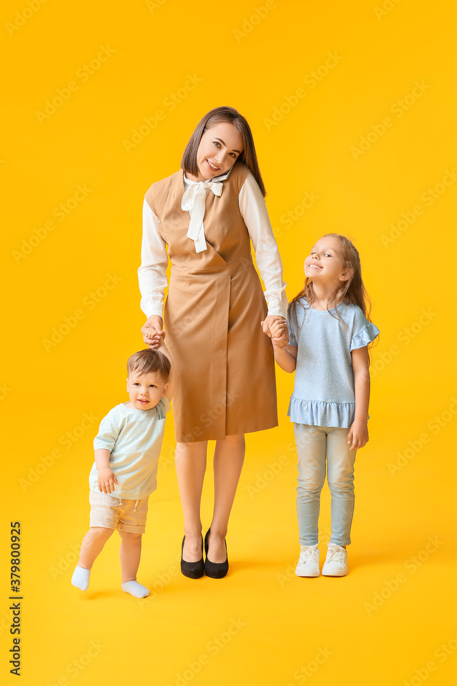 Working mother with little children on color background