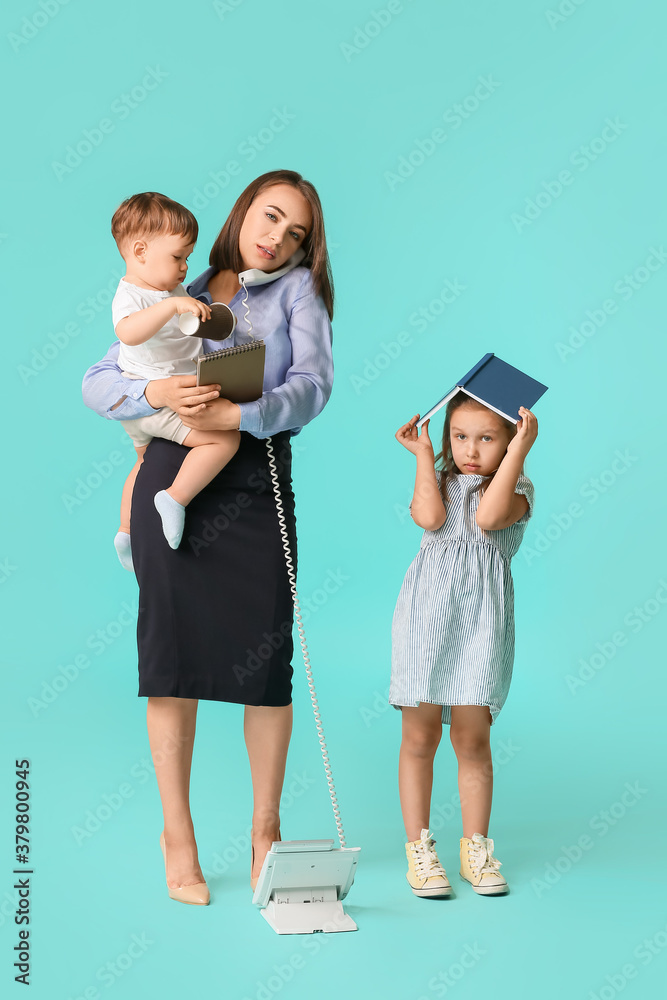 Working mother with naughty little children on color background