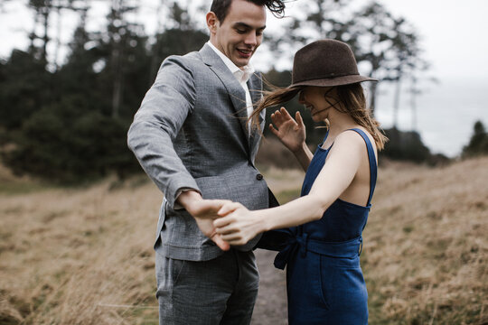 young couple dancing together on windy day outside