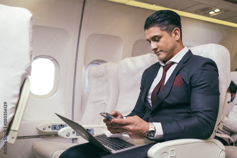 Male passenger business man using smartphone checking work or news on airplane cabin. wireless techn