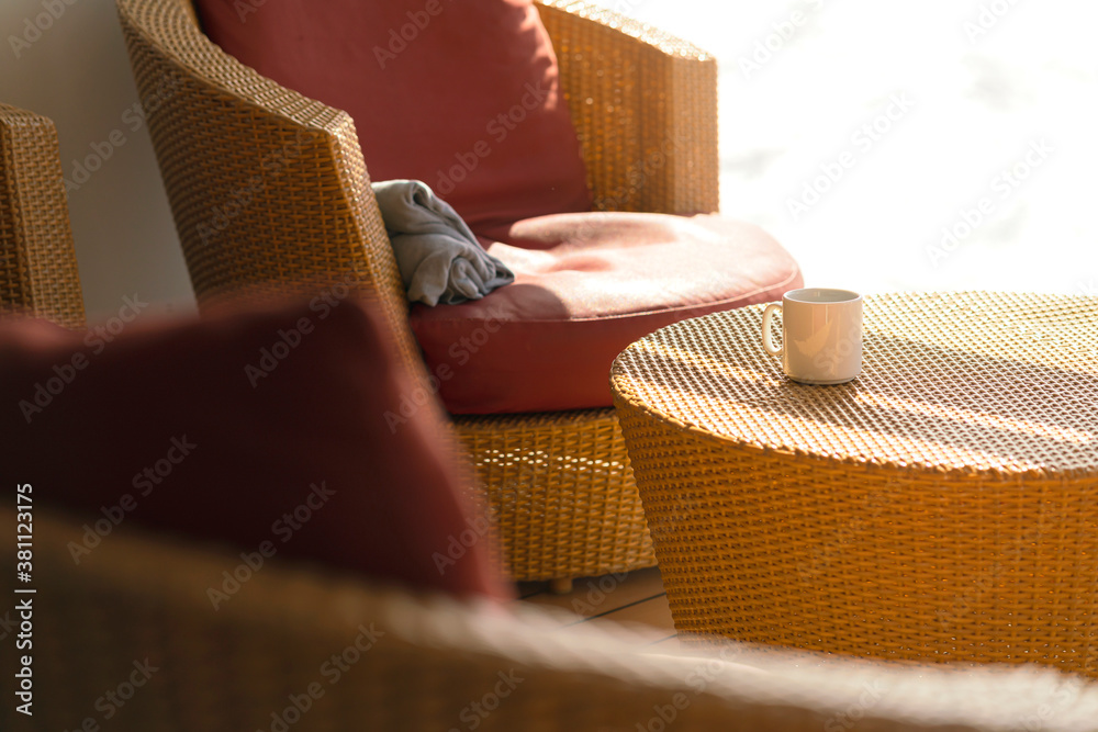 早上休闲周末，在木制露台上的藤桌上喝热饮咖啡，阳光来自窗户ca