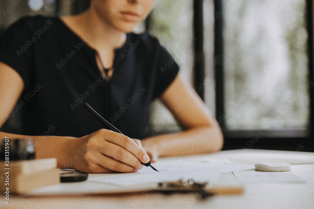 Female calligrapher working. People and art concept.