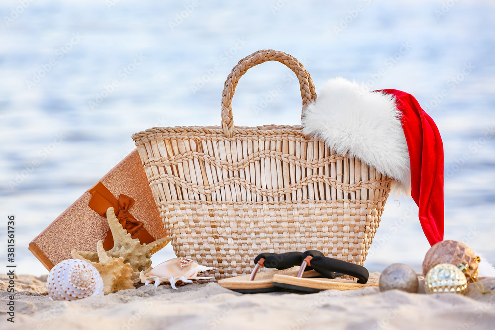 海边沙滩包和圣诞老人帽的组合。圣诞假期概念
