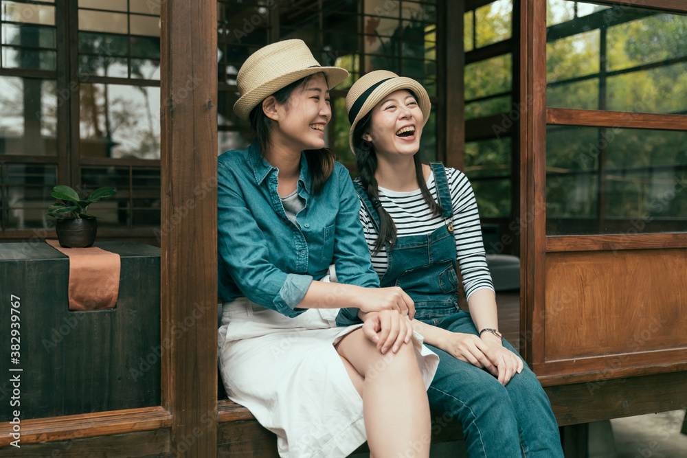 一群戴草帽的女性好朋友坐在台阶上，用木制日语开怀大笑