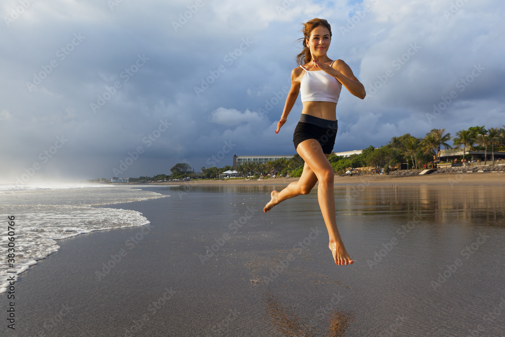 赤脚的年轻女孩，苗条的身体，沿着水池边的海浪奔跑，以保持身体健康并燃烧脂肪。