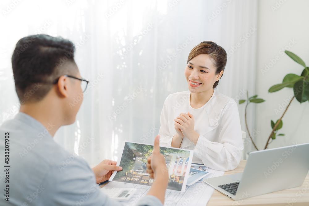 Young Asian man at real estate agent in office with famale seller.
