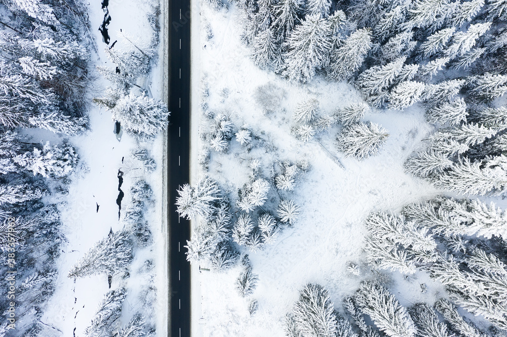 Winter chill. Natural winter landscape from air. Aerial view on the road and forest at the winter ti