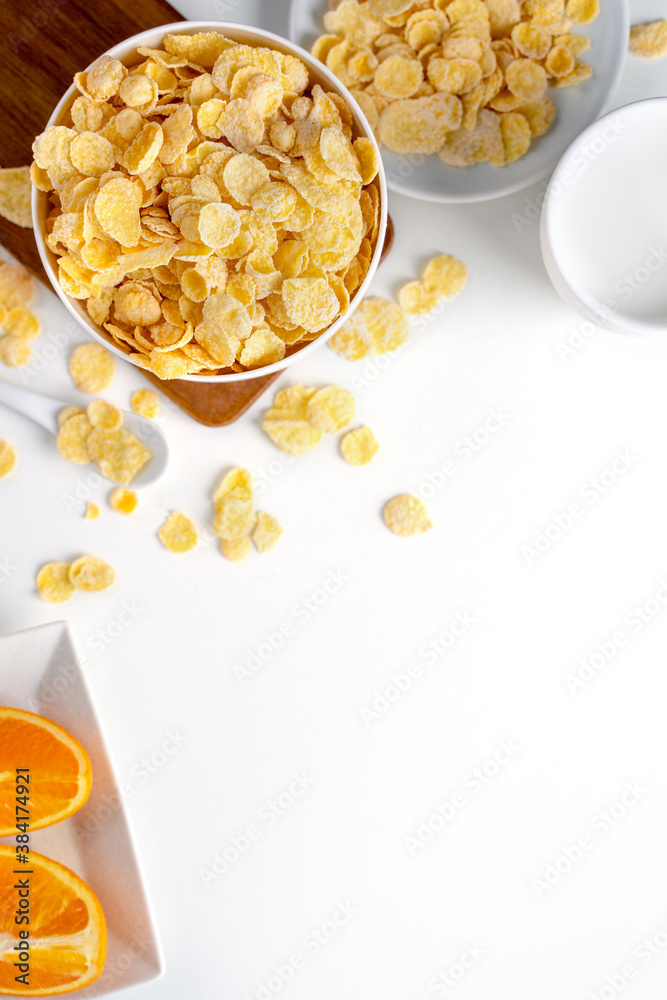 Top view of corn flakes bowl with milk on white background.