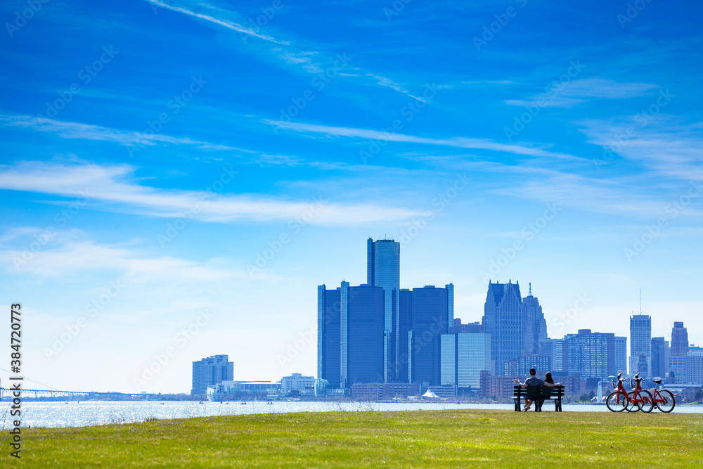 Detroit river with view of downtown and lovely couple sit in the bench on Sunset Point over from Bel