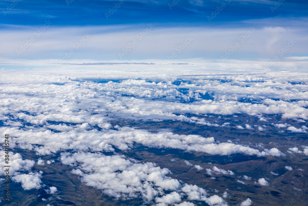 在阳光明媚的日子里俯瞰云朵和山峰。从飞机上俯瞰山景。